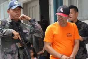 En esta foto de junio de 2014, un oficial de policía filipino escolta al comandante de Abu Sayyaf, Khair Mundos, desde el tribunal [Mark Cristino/AP]